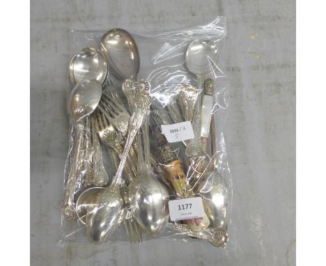 A collection of cutlery including a silver fork (67g) and other plated items 