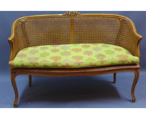 A caned two seater settee with upholstered cushion on cabriole supports, L 130cm 