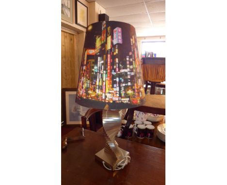 A contemporary silvered lamp with a spiral stepped base and cityscape shape H 68cm 