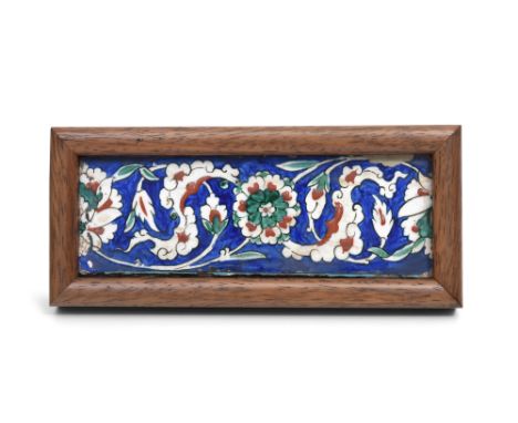 AN IZNIK POTTERY BORDER TILE PANEL WITH ROSETTES AND CLOUD COLLAR Ottoman Turkey, second half 16th centuryOf narrow rectangul