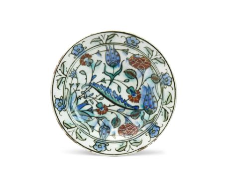 A SMALL IZNIK POTTERY DISH WITH SAZ LEAF AND FLOWERS Ottoman Turkey, ca. 1580 - 1600Of shallow rounded shape, resting on a sh