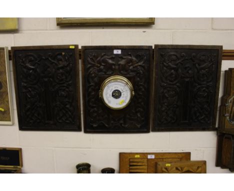 A pair of ornate carved wooden panels; together with one other similar mounted with a brass cased barometer