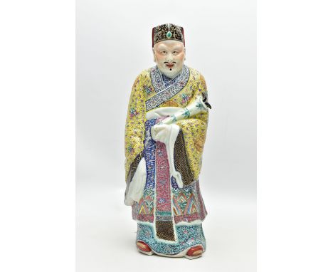 A 20TH CENTURY CHINESE FAMILLE ROSE STANDING FIGURE, modelled as a male wearing flowing robes holding a bamboo decorated vess