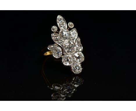 AN EARLY 20TH CENTURY DIAMOND DRESS RING, comprised of seventeen old cut diamonds ranging in size, prong and bezel set in a w