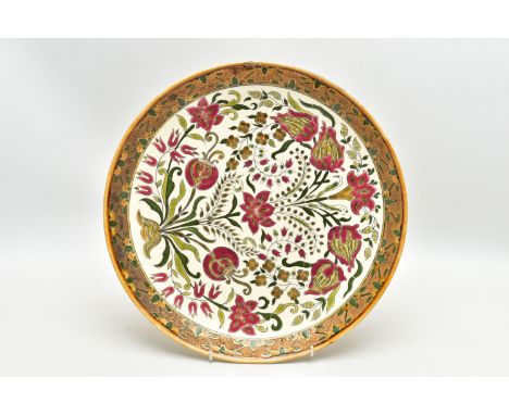 A ZSOLNAY PECS POTTERY POLYCHROME ENAMELLED CHARGER, ochre rim surrounding a rough textured gilt and enamelled border, the ce