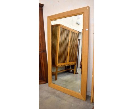 A large modern bevelled wall mirror in moulded light oak frame, 110 cm wide x 183 cm high