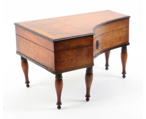 A good Palais Royal ‘grand piano’ sewing box, circa 1830, the case in satinwood and raised on five part ebonised turned legs,