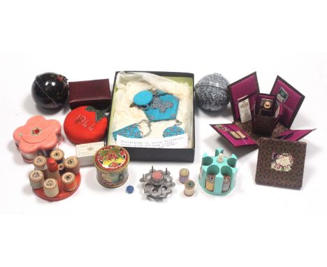 A mixed lot, sewing, comprising three plastic and one metal reel stand, two plastic thread balls, a tin thread cylinder, a mo