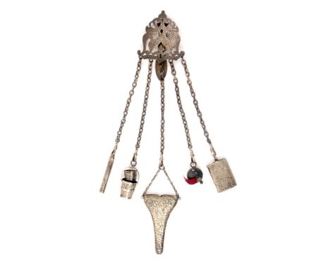 A silver chatelaine, 1886, the hook with floral engraved and elaborately pierced mount to five chains and matching accessorie