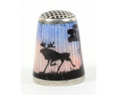 A Norwegian silver and enamel thimble with waffle top, depicting a moose, birds and silhouetted trees illuminated by the midn