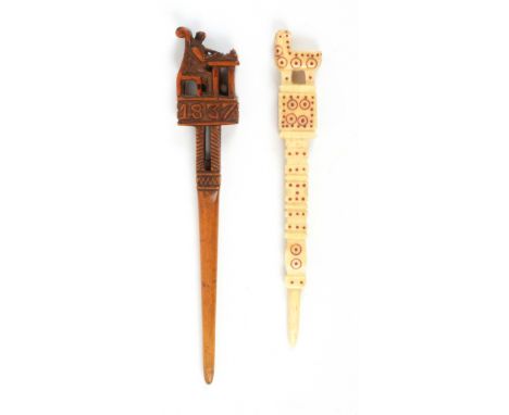 Two fine folk art stilettos, comprising a carved fruitwood example, the shaft below a carved lantern with ball over a plinth 
