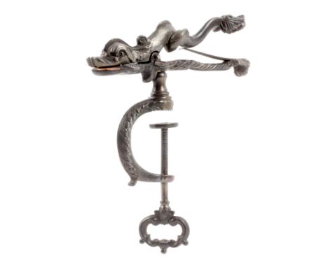 A cast iron sewing clamp, the decorative ‘C’ form frame with open head screw, the sprung clamp in the form of a dolphin, 16cm