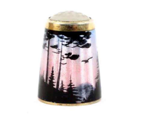 A Norwegian silver gilt and enamel thimble with moonstone top, depicting birds, silhouetted trees and mountains illuminated b
