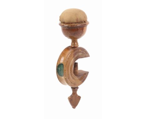 A wooden label decorated Tunbridge ware sewing clamp, the ring turned ‘C’ frame below a bowl form pin cushion with replacemen