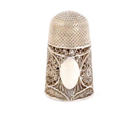 A late 18th Century English silver filigree thimble, of tall elegant form with pointed oval cartouche within quill work.