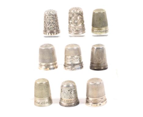 Nine raised letter or inscribed English thimbles, comprising seven hallmarked silver examples ‘Stratford-on-Avon’, ‘W.E. Watt