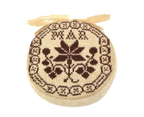 A good sampler style knitted disc form pin cushion, late 18th/early 19th Century, in brown and cream, one side with a geometr