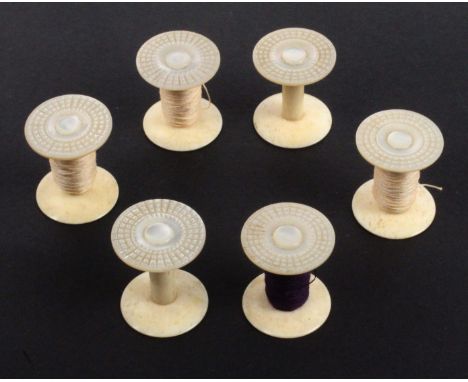 A set of four and two mother of pearl top reel holders, the cut circular tops on bone stems and bases, 2.4cms dia., 2.8cms hi
