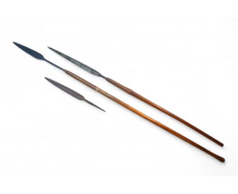 Two African tribal assegai style spears, both is wooden shafts, longest 134cm overall, together with a spearhead. (3)