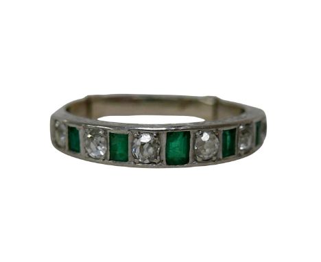 A white metal diamond and emerald ring, with six graduated round cut diamonds, largest approximately 3mm diameter, smallest a