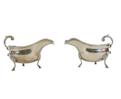 A pair of George VI silver sauce  boats Mappin and Webb London 1937/38 with acanthus scroll handle and shaped legs on a pad f