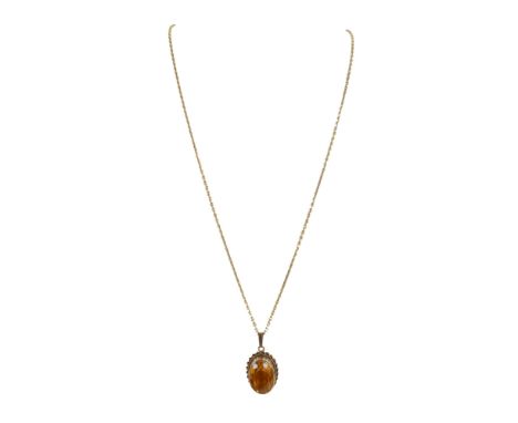 A gold and citrine pendant with gold chain, the oval citrine in 9ct gold with rope twist border, the chain 18ct, marked 750, 