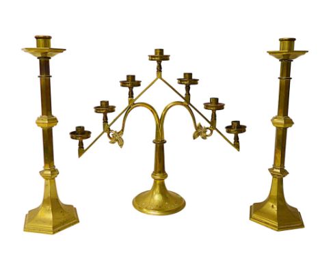 A brass altar twin branch candlestick and a pair of single candlesticks, largest 52 by 15 by 47cm tall.(3)