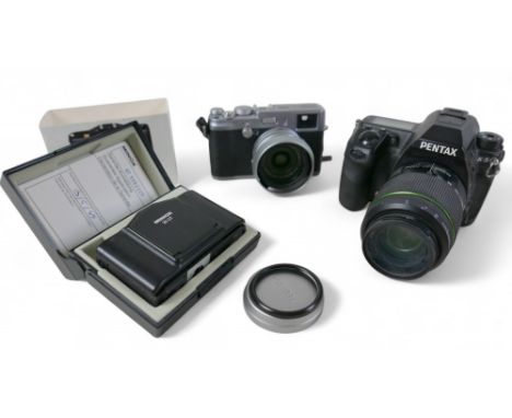 A Pentax K-5 camera a Fujifilm digital FinePix X100 camera and a Minox 35 GT camera. (3)