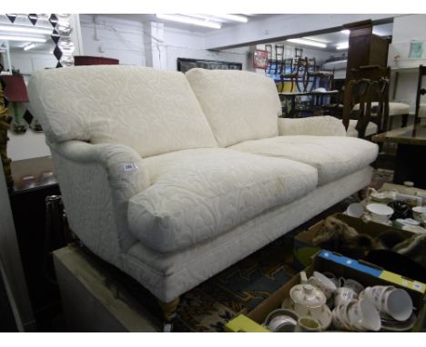 A WHITE UPHOLSTERED TWO SEATER SOFA