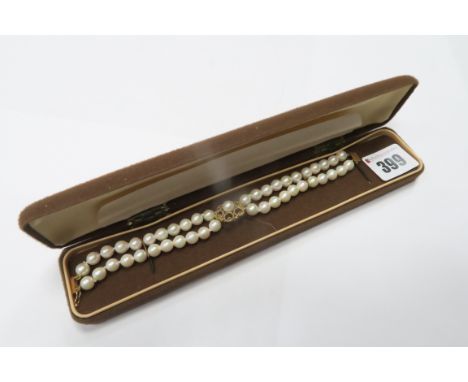 A Two Row Pearl Bead Bracelet, of uniform design, detailed to the centre with a 9ct gold openwork flowerhead panel.