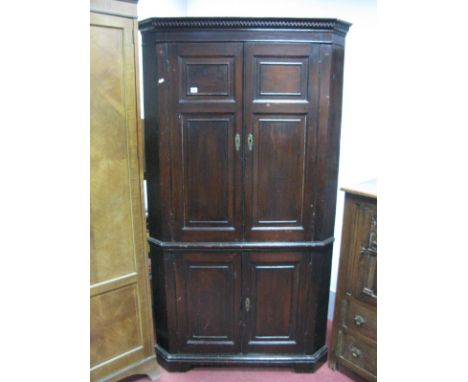 An XVIII Century Painted Pine Double Height Corner Cupboard, with dentil cornice, panelled doors and shaped internal shelves,
