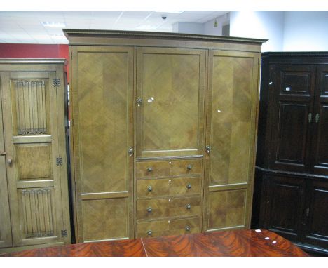 An Early XX Century Mahogany Triple Wardrobe, stepped pediment, centre section with a panelled cupboard, over four long drawe