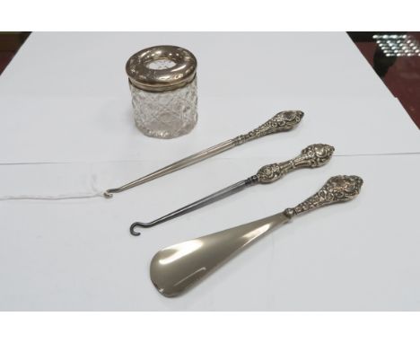 A Chester Hallmarked Silver Topped Glass Tidy Jar; together with two hallmarked silver handled button hooks and a shoe horn.