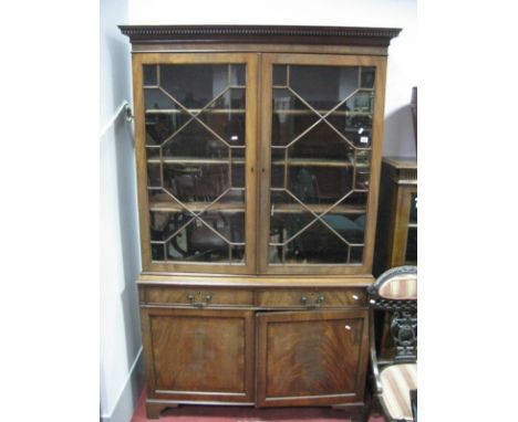 A Mahogany Book Cabinet, with dentil and stepped cornice, astragal glazed doors, over twin drawers and cupboard doors on brac