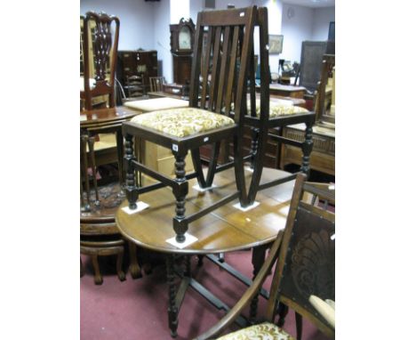 A 1920's Oak Drop Leaf Table, on bobbin and block supports; together with a pair of oak dining chairs.