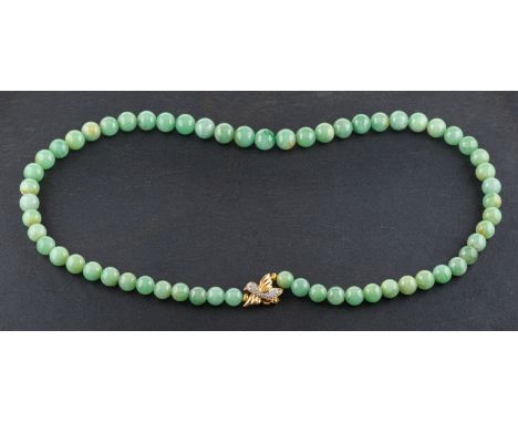 A graduated, single-row, jade bead necklace, diameter of beads ca. 7.2-9.2mms, with bird-shaped clasp stamped '18K' set with 