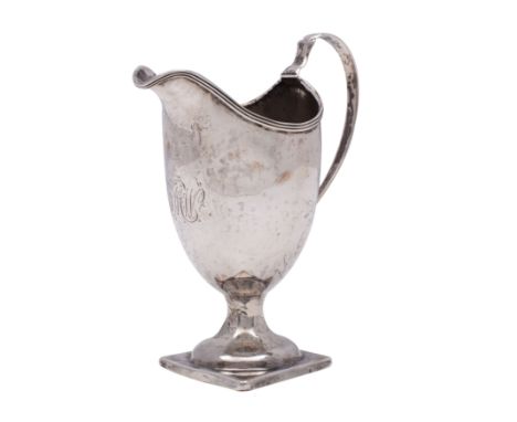 A Georgian unhallmarked silver helmet-shaped pedestal cream jug with reeded edge, scroll handle and square foot, 12.5cm high,