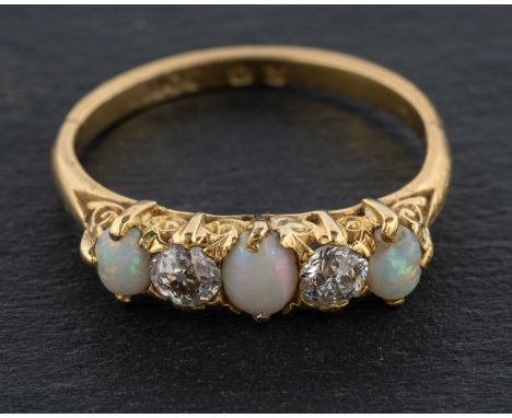 An oval, cabochon-cut opal and old-cut diamond, five-stone ring, total estimated diamond weight ca. 0.30ct, I-J colour, SI1-2