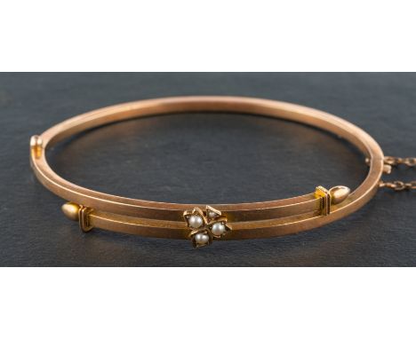 A late 19th/ early 20th century, seed pearl hinged bangle, with clover frontispiece, stamped '15', inner length ca. 6.3cm, to