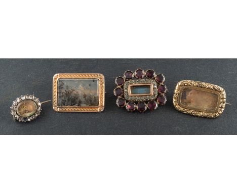 Four memorial brooches, including a dendretic quartz brooch; a brooch with foliate engraved surround; a seed pearl and garnet