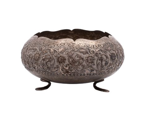 An Indian silver circular sugar basin embossed with flowerheads and scrolling foliage, on tripod feet, 12.5cm diameter, 183gm