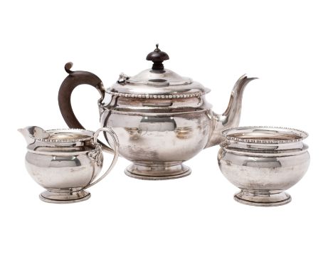 A George V silver three-piece pedestal tea service, makers Mappin &amp; Webb, Birmingham 1921 of circular form with reel turn