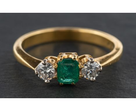 An 18ct gold, emerald and diamond, three-stone ring, estimated emerald weight ca. 0.20ct, total estimated diamond weight ca. 