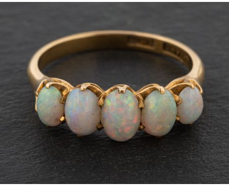 An oval, cabochon-cut opal, five-stone ring, stamped '18CT', length of ring head ca. 1.8cm, ring size N, total weight ca. 3.4