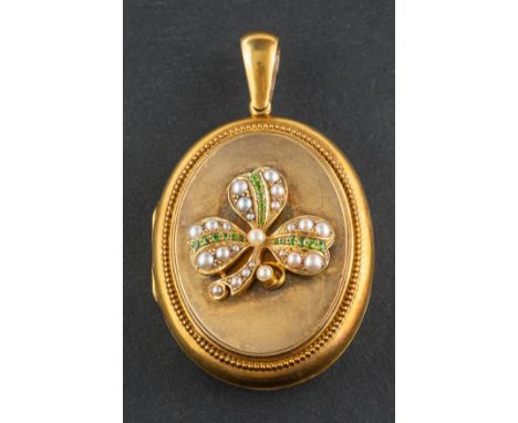 An oval, locket pendant, with probably peridot and seed pearl clover leaf design, within beaded surround, length (inc jump ri