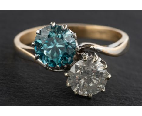 A round, brilliant-cut diamond and round, mixed-cut blue zircon cross-over ring, estimated diamond weight ca. 0.90ct, H-I col