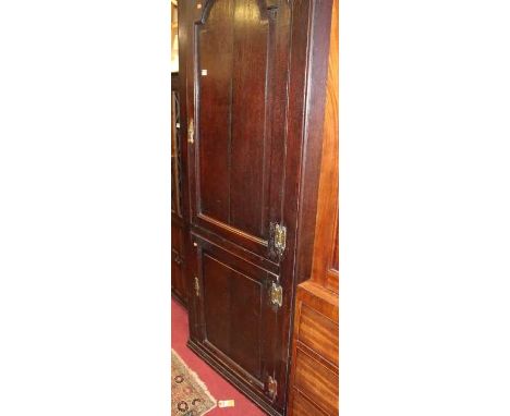 A circa 1800 provincial oak freestanding  corner cupboard, the arched recessed panelled upper door over further recessed pane