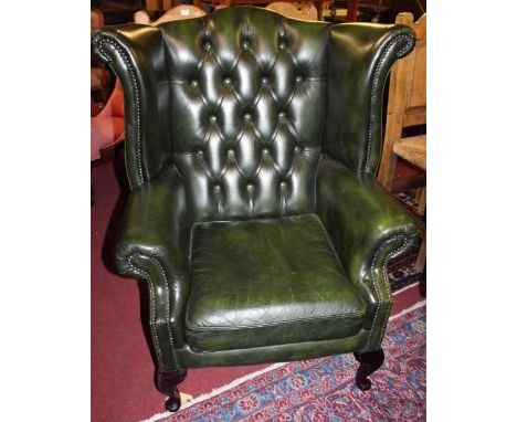 Two similar contemporary green leather buttonback upholstered and studded wingback scroll armchairs, each with removable cush