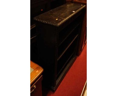 An early 20th century line carved and ebonised oak low freestanding open bookshelf, having three adjustable shelves, width 91