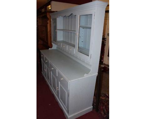 A modern pine and later blue painted kitchen dresser, the upper section with two-tier open plate rack over three short drawer